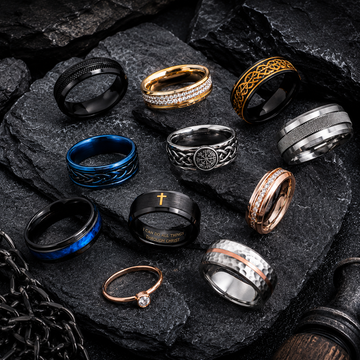 Men's and women's stainless steel, titanium, Viking, spinner and couple rings on dark slate background.