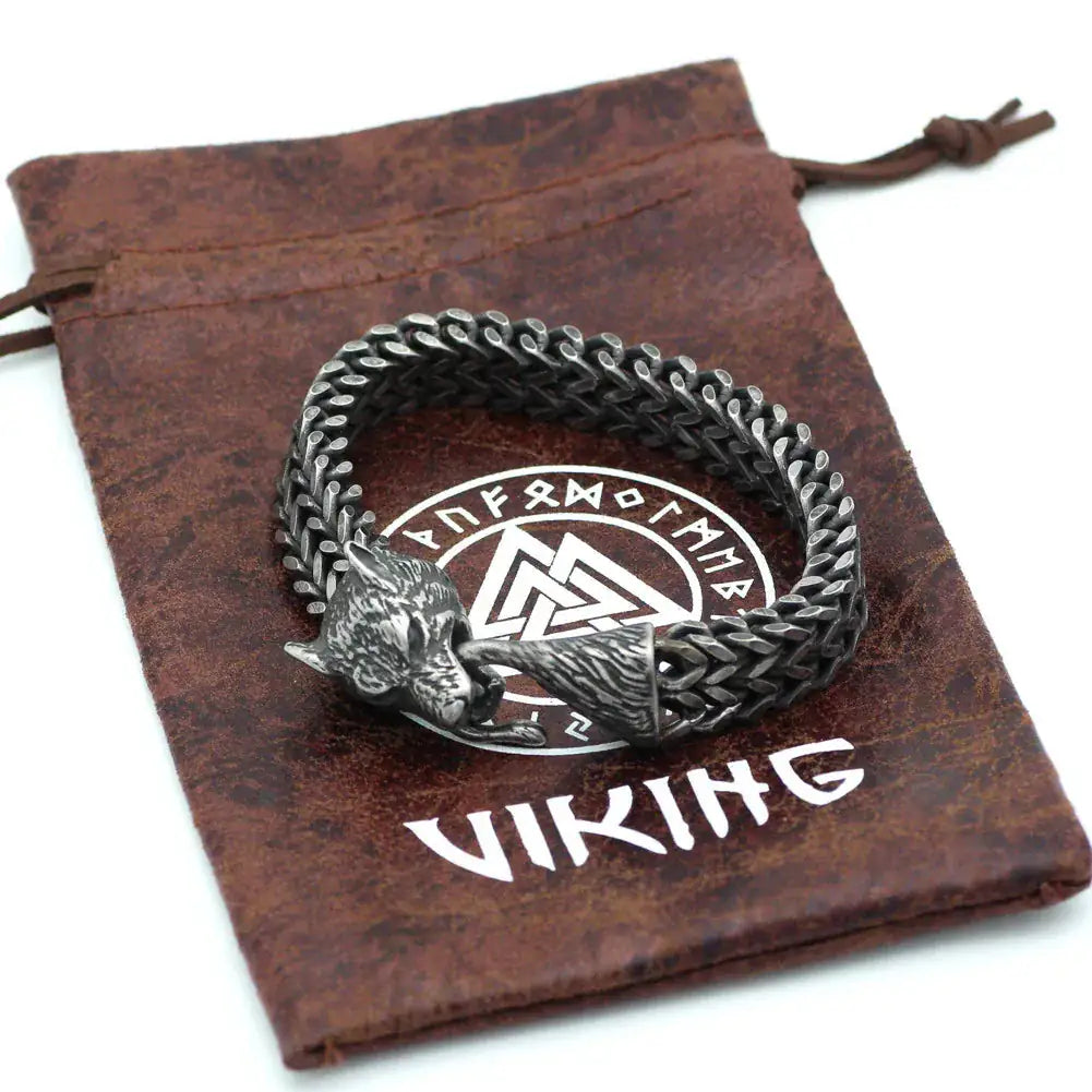 Men’s Wolf Head Bracelet displayed on a Viking-themed pouch with a stainless steel Cuban chain design.